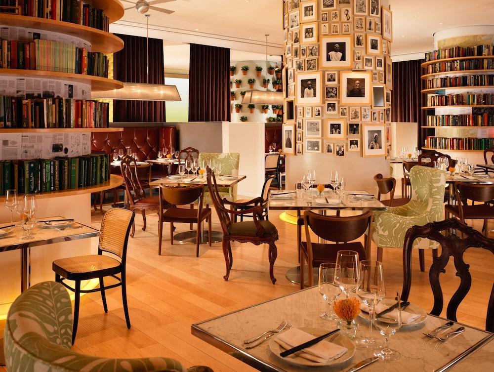 Hotel St Martins Lane Londýn Exteriér fotografie The photo depicts an elegant restaurant interior with a modern and inviting atmosphere. The space features a combination of wooden flooring and stylish furniture, including uniquely designed chairs and tables. There are bookshelves lining the walls, 