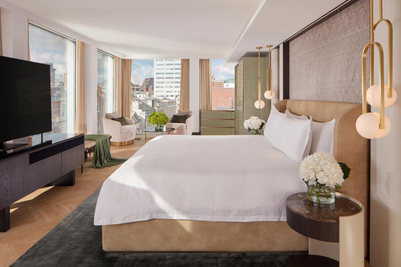Hotel St Martins Lane Londýn Exteriér fotografie The photo shows a modern hotel room featuring a large, comfortable bed with white bedding. The room has large windows that provide natural light and a view of the cityscape outside. There is a stylish flat-screen TV mounted on the wall and a dark woo