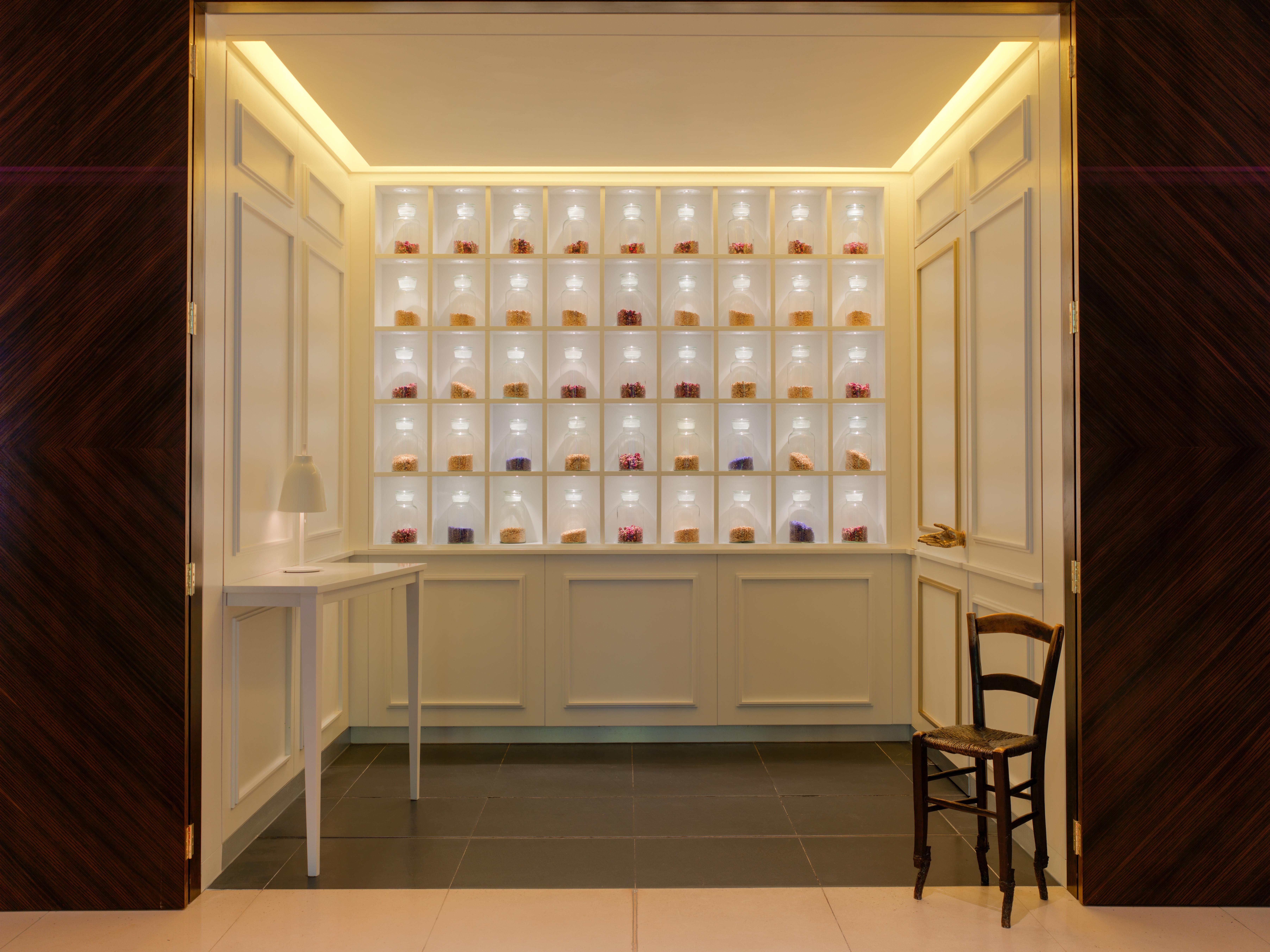 Hotel St Martins Lane Londýn Exteriér fotografie The photo shows an elegant interior space that features a display wall with multiple shelves. Each shelf is illuminated, showcasing a variety of small items, likely decorative or artisanal products. The wall is light-colored, creating a bright atmosp