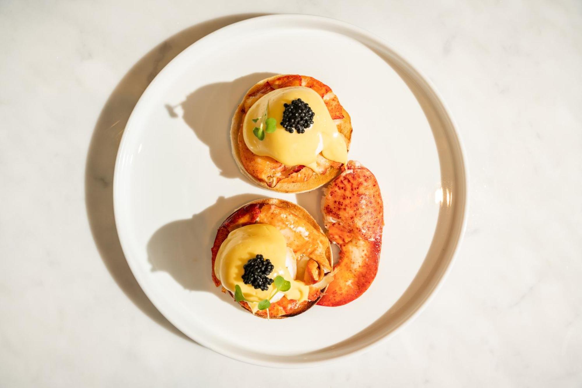 Hotel St Martins Lane Londýn Exteriér fotografie The photo shows a plate with two servings of a dish that appears to be eggs Benedict. Each serving consists of a toasted English muffin topped with poached eggs, creamy hollandaise sauce, and garnished with black caviar and possibly some green onions