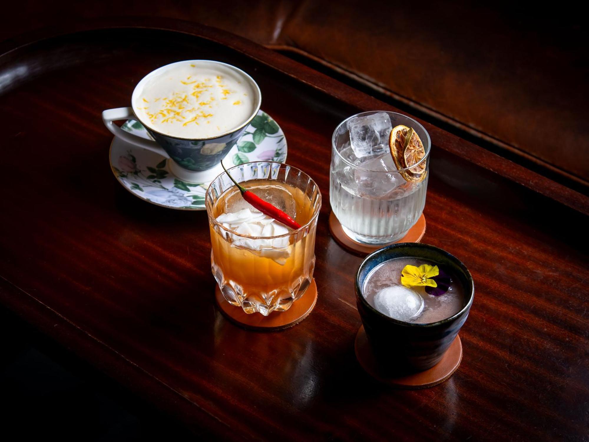 Hotel St Martins Lane Londýn Exteriér fotografie The photo features a selection of four different drinks arranged on a wooden surface. 

1. On the left, there is a delicate cup with a floral design, containing a creamy beverage topped with what appears to be shavings or sprinkles, possibly coconut 