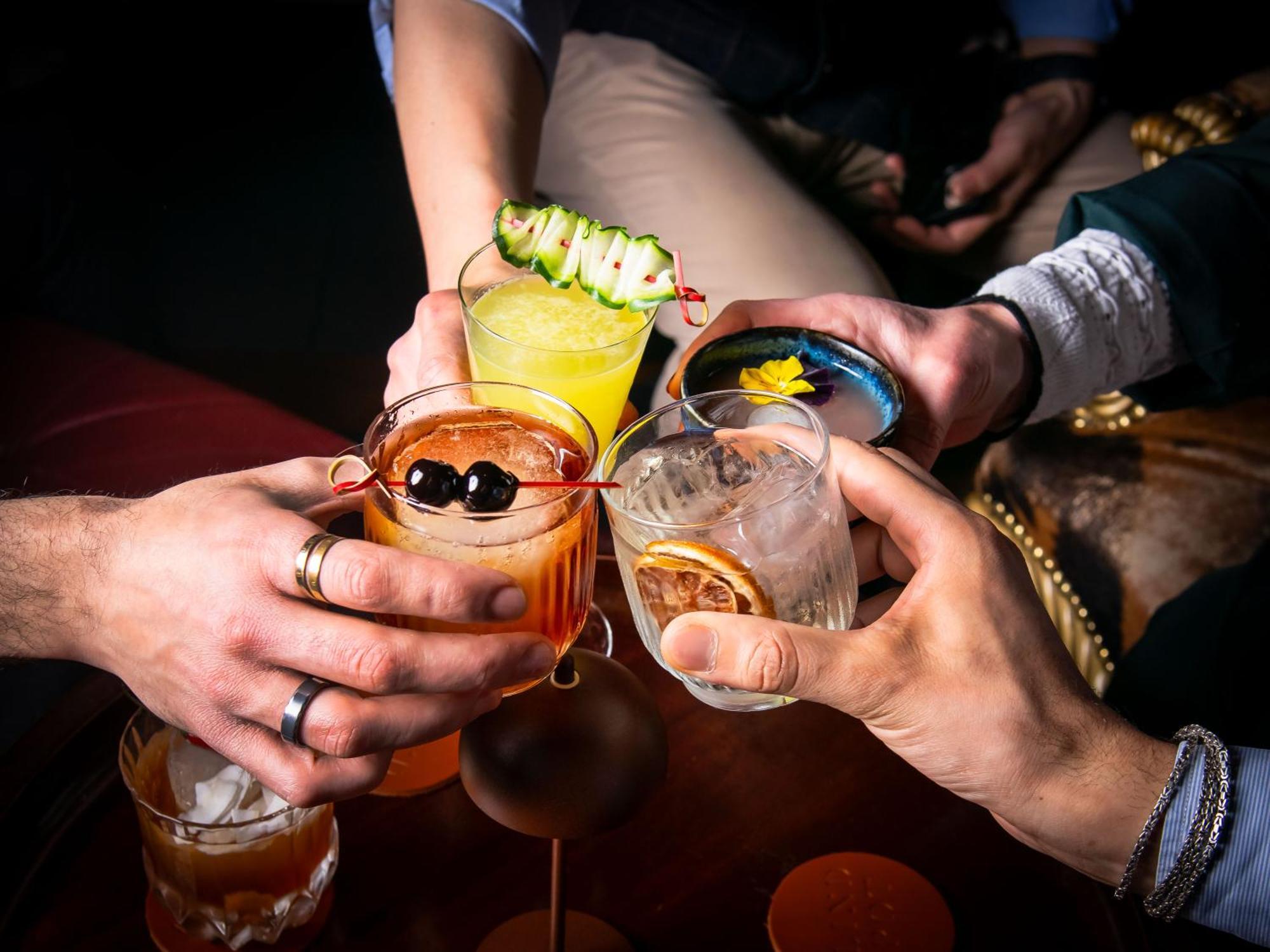 Hotel St Martins Lane Londýn Exteriér fotografie The photo features a group of hands holding different colorful cocktails, suggesting a celebratory atmosphere. Each drink has distinct garnishes: one has a cucumber slice, another displays a flower, and others feature fruits and decorative elements. 