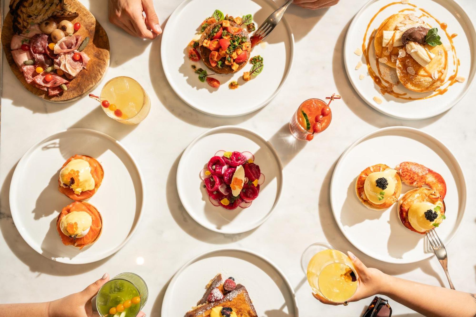 Hotel St Martins Lane Londýn Exteriér fotografie The photo showcases a vibrant spread of food arranged on a table. There are several white plates displaying a variety of dishes. 

1. **Savory Dishes**: One plate features a colorful salad with tomatoes and greens. Another looks like a decadent dish,