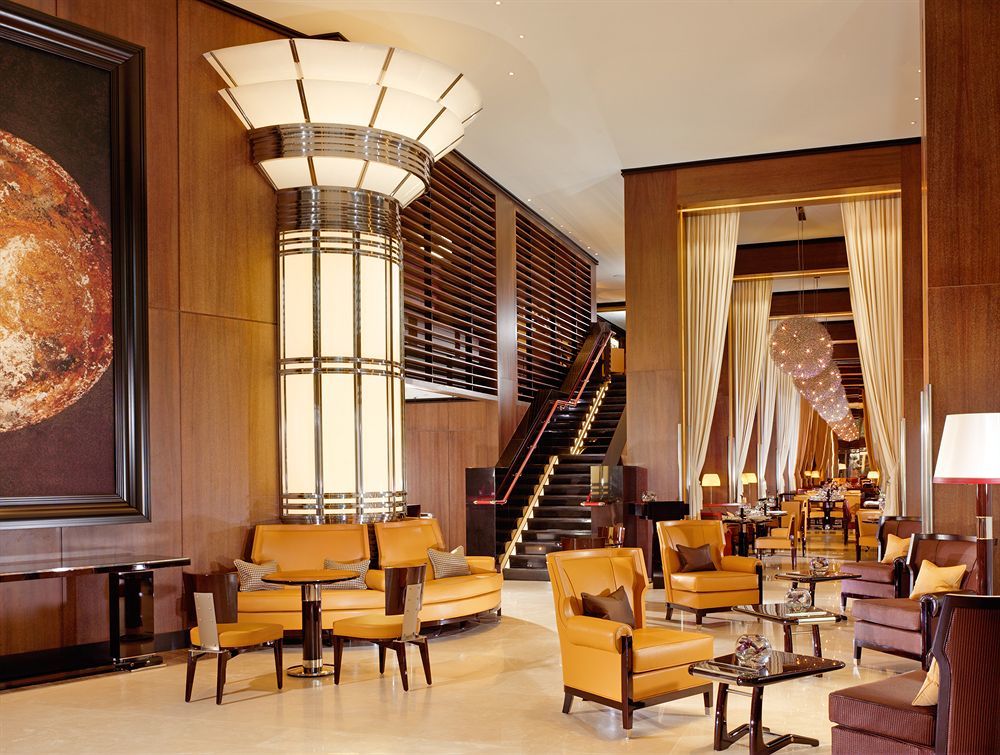 Hotel St Martins Lane Londýn Exteriér fotografie The photo depicts a sophisticated and elegant hotel lobby. The interior features a modern design with polished wooden accents and warm lighting. In the center, there is a large, stylish column with art deco elements. Surrounding the column are plush 