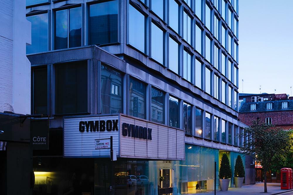 Hotel St Martins Lane Londýn Exteriér fotografie The image shows a modern building with a distinctive architectural design. The facade features large glass windows, and the lower section includes a sign that reads "GYMBOX." There appears to be some greenery in front of the building, and the scene i
